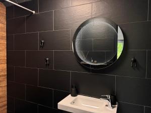 a bathroom with a mirror and a sink at HARMONY Slow Living Stay in Bigauņciems