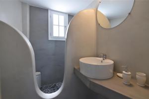 a white bathroom with a sink and a mirror at Vagia Calm House in Parikia +9 photos