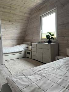a room with two beds and a window in a room at "Morze Spokoju" domki letniskowe in Darlowko