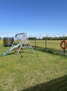 a playground with a slide in the grass at "Morze Spokoju" domki letniskowe in Darlowko