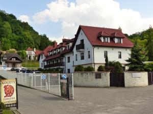 Casa blanca con techo rojo y valla en Apartament 10 Poranek - Pod Aniołem, en Kazimierz Dolny