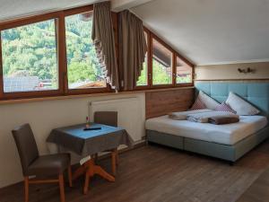 sypialnia z łóżkiem, stołem i oknami w obiekcie Living-Apart Anita w mieście Oetz
