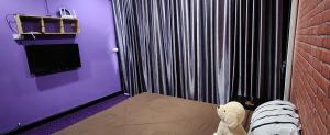 Ein Teddybär liegt auf einem Bett in einem Zimmer in der Unterkunft Ber Ben House in Bang Su