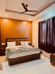 a bedroom with a bed and a ceiling fan at Hotel Wisteria Haridwar in Haridwār