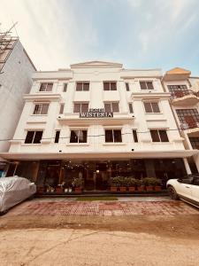 a large white building with a sign on it at Hotel Wisteria Haridwar in Haridwār