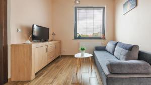 a living room with a couch and a flat screen tv at Obrońców Wybrzeża, Sun & Snow in Puck