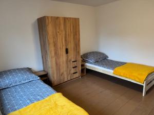 Habitación con 2 camas y armario de madera. en Niepołomice,noclegi, pokoje, cały dom, kwatery pracownicze, en Niepołomice