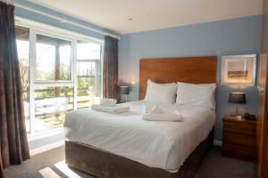 a bedroom with a large bed with a large window at The Cornwall Hotel Spa & Lodges in St Austell +82 photos