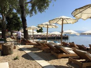 a group of chairs and umbrellas on a beach at Daniel studio in Corfu