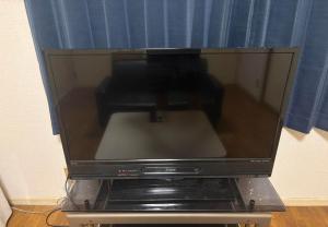a television sitting on top of a stand at RHK Guest House102 in Tokyo