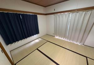 an empty room with a window and curtains at RHK Guest House102 in Tokyo