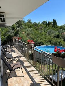 a balcony with chairs and a swimming pool at Apartman Buljarica-Bačvice 2 in Kaluđerac