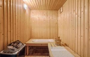 a sauna with a table and a stove in it at Lovely Home In Løkken With Sauna in Løkken