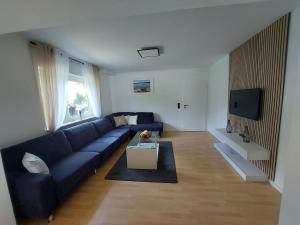 a living room with a blue couch and a tv at Apartment Nähe Limburg Diez in Heistenbach
