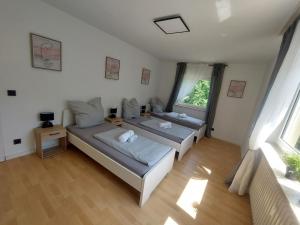 two beds in a room with two windows at Apartment Nähe Limburg Diez in Heistenbach