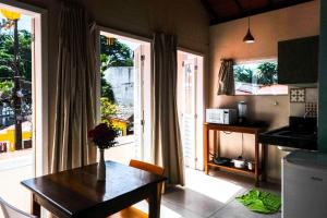 a kitchen with a table and a door to a balcony at Jardim UIXA in Ilha de Boipeba +70 photos