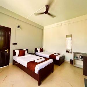 a bedroom with two beds and a ceiling fan at DELI-BAIAR guest house in Mawlynnong