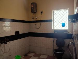 a bathroom with a toilet and a window at Kodai Queen Homestay in Kodaikānāl +9 photos