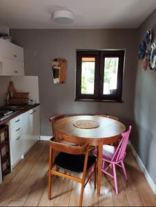 a kitchen with a table and chairs in a kitchen at Sosnowy domek in Pobierowo