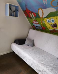 a room with a bed with a painting on the wall at Sosnowy domek in Pobierowo