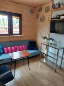 a living room with a blue couch and a table at Sosnowy domek in Pobierowo