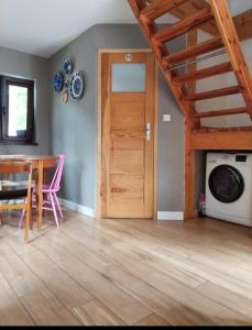 a living room with a table and a wooden door at Sosnowy domek in Pobierowo +7 photos