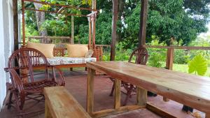 ein Holztisch und Stühle auf einer Terrasse in der Unterkunft Shalom Wellspring Cottage in Malindi