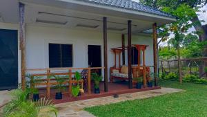ein Haus mit einer Veranda mit Stühlen und Pflanzen in der Unterkunft Shalom Wellspring Cottage in Malindi