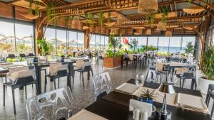 a restaurant with tables and chairs with the ocean in the background at Siu Collection - Ultra All Inclusive in Beldibi