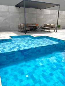 a large swimming pool with a table and chairs at Luxury house in Martil in Martil