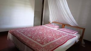 ein Bett mit zwei Kissen darauf in einem Zimmer in der Unterkunft Shalom Wellspring Cottage in Malindi
