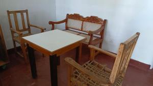 mesa, 2 sillas y mesa y sillas de madera. en Shalom Wellspring Cottage, en Malindi