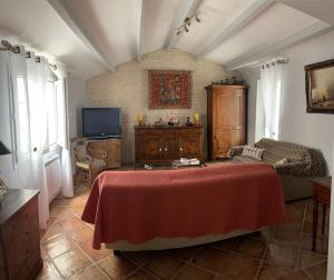 a living room with a bed and a tv at La traboule in La Tranche-sur-Mer