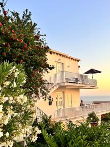 a large building with a balcony and an umbrella at Indigo Cavtat Apartments in Cavtat