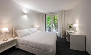 Habitación blanca con cama, escritorio y ventana en Bed and Breakfast Saint Alliance, en Crikvenica