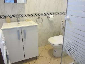 a bathroom with a white toilet and a sink at cabo dream 75 in Cabo Negro