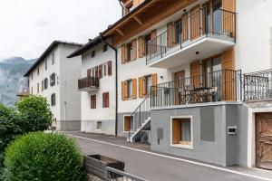 un edificio de apartamentos con balcones en una calle en Trilo Larice riflesso, en Fai della Paganella