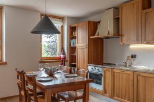 cocina con mesa con sillas y comedor en Trilo Larice riflesso, en Fai della Paganella