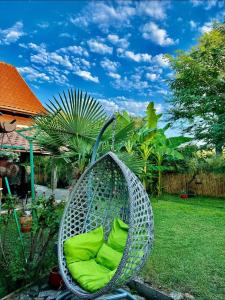 a chair with green cushions sitting in a yard at Guest House Yanakievi in Sinemorets