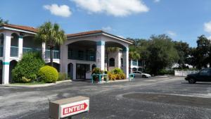 Un edificio con un coche aparcado en un estacionamiento. en Flamingo Inn, en Kissimmee