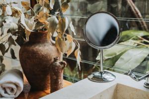 a mirror sitting on a table next to a vase at Leaves & Fishes - Private group escape in the Hunter Valley in Lovedale