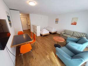 a living room with blue chairs and a table at Cresta Apartments - Studios in Davos