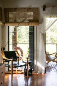 a living room with a chair and a window at Leaves & Fishes - Private group escape in the Hunter Valley in Lovedale