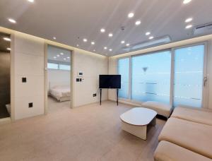 een woonkamer met een bank en een televisie bij Luxury Terrace House in Seoul