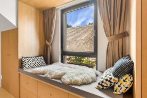 a room with a window and a bed with pillows at IMPERFECT house in Râşnov +27 photos