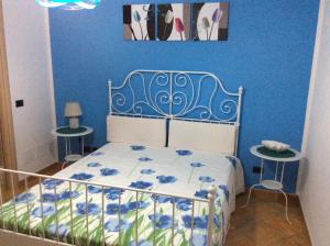 una camera da letto con un letto con una parete blu di B&B in Residence "...a due passi dalla Scala dei Turchi" a Porto Empedocle