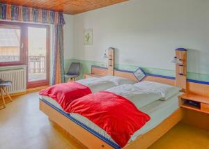 a bedroom with a large bed with red sheets at Reiterlandhof in Neukirchen