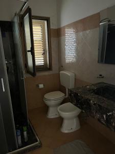 a bathroom with a toilet and a sink and a mirror at Casa vacanze Metauria in Gioia Tauro +24 photos
