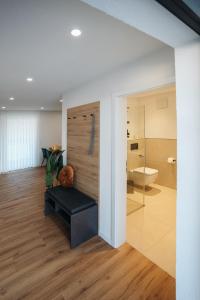 a bathroom with a bench and a toilet in a room at Be Grand Apartments Rust in Rust