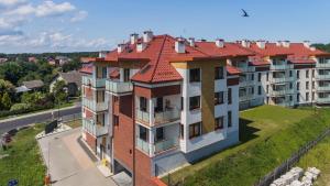 an apartment building with a red roof at Perła Mierzei, Sun & Snow in Sztutowo